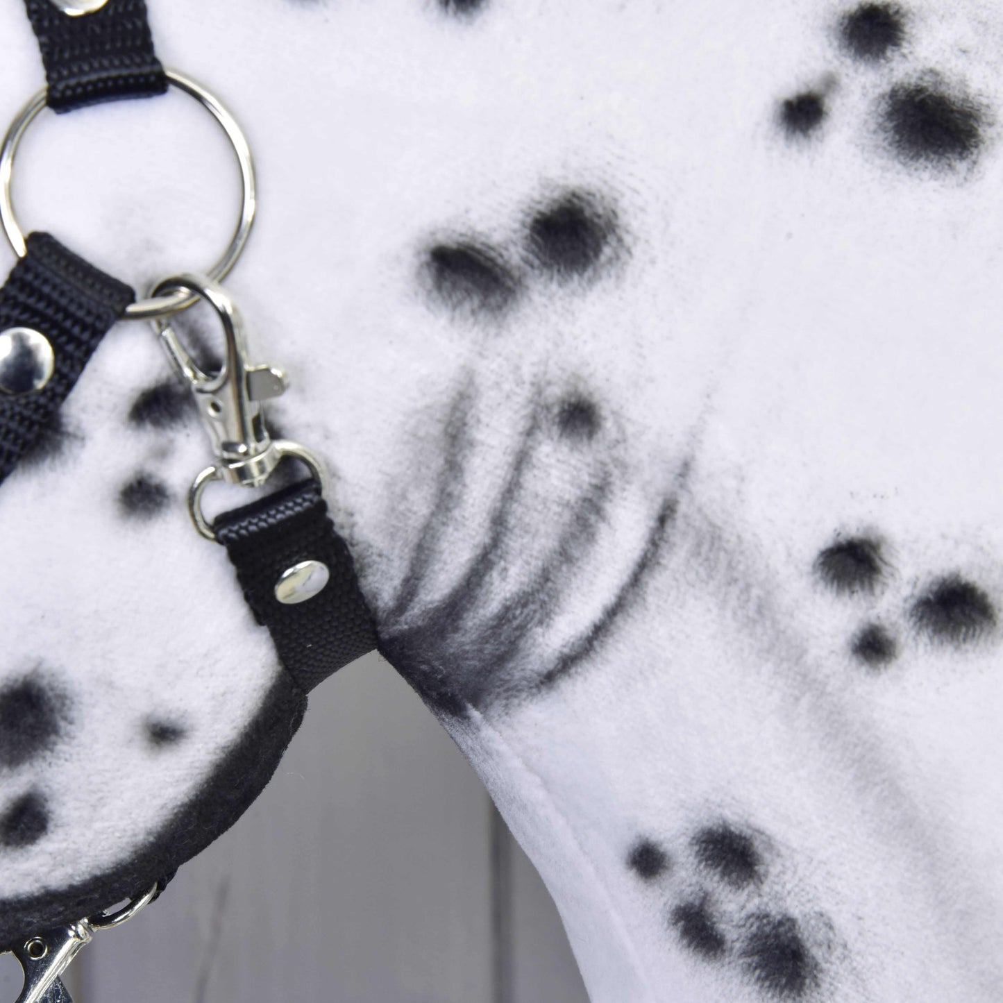 Detail Hobby Horse Chantal od LarDen, s bílým krkem s černými skvrnami a černou ohlávkou se stříbrnými kroužky a přezkami. Jedinečný ručně vyráběný vzor srsti zvýrazňuje tuto krásnou klisnu.