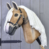 Hobby Horse Connie s černou ohlávkou od Hobby Horse LarDen s realistickým světle béžovým obličejem, bílou lysinou, černou ohlávkou a dlouhou bílou přízovou hřívou na dřevěné tyči, vystavený před šedou dřevěnou stěnou.