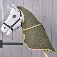 Šedý Hobby Horse s černou uzdečkou má na sobě Deka s odepínatelným krkem Rubby od Hobby Horse LarDen, zelenou kvalitní deku se vzorem srdcí a barevným lemováním, zobrazenou před dřevěnou stěnou.