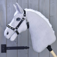 Ohlávka s beránkem z koženky Espresso od Hobby Horse LarDen na šedém Hobby Horse s bílou hřívou a černou uzdečkou, nasazeném na dřevěné tyči, před světle šedou dřevěnou stěnou s černým pantem vlevo.