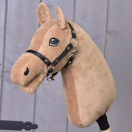 Plyšová hračka Build your horse od related_to_12441055625556 s karamelově světle hnědou srstí, cappuccino hřívou, černou uzdečkou a přátelským vyšívaným okem, naaranžovaná před šedou dřevěnou stěnou.