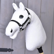 Build your horse od related_to_12441055625556 je bílý plyšový Hobby Horse s přízovou hřívou a černým postrojem na dřevěné tyči, zobrazený na pozadí světle šedých dřevěných panelů.