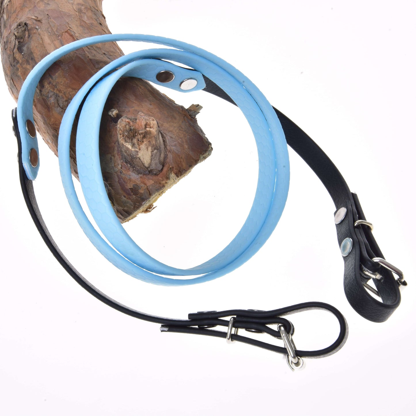 Otěže pogumované Light blue od Hobby Horse LarDen, se světle modrou a černou kůží, kovovou přezkou a designem inspirovaným uzdečkou, omotané kolem dřeva a zobrazené na bílém pozadí.