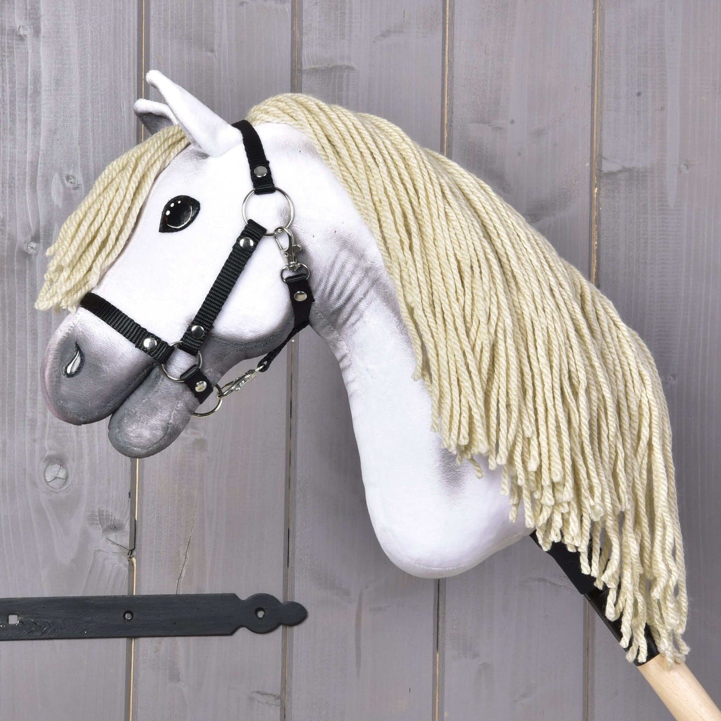 Hobby Horse Little Lady s černou ohlávkou od Hobby Horse LarDen má bílou plyšovou hlavu, hustou blond hřívu z příze a černou ohlávku na dřevěné tyči – ideální pro nápaditou hru nebo trénink drezury.