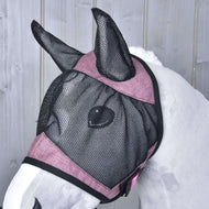 Bílý kůň má na sobě Maska proti hmyzu de Luxe Pink od Hobby Horse LarDen, pratelnou černo-růžovou síťovanou masku zakrývající uši a obličej, na světle šedém dřevěném pozadí.
