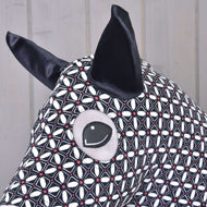 Detail Hobby Horse ochranného obleku DeLuxe (Lycra) od Hobby Horse LarDen z pratelné černobílé geometrické lycry s velkýma černýma ušima a prošívaným okem na světlém dřevěném pozadí.