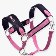 Ohlávka s beránkem LarDen Pink od Hobby Horse LarDen v růžové a černé barvě s kovovými kroužky, nastavitelnými popruhy, měkkým polstrováním pro pohodlí, růžovými kožešinovými detaily a částečně viditelným nápisem „Den“ na nánosníku.