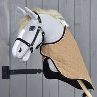 Šedý látkový Hobby Horse od Hobby Horse LarDen s černou uzdečkou a převozní dekou Paris, na dřevěné tyči, umístěný před dřevěným plotem.