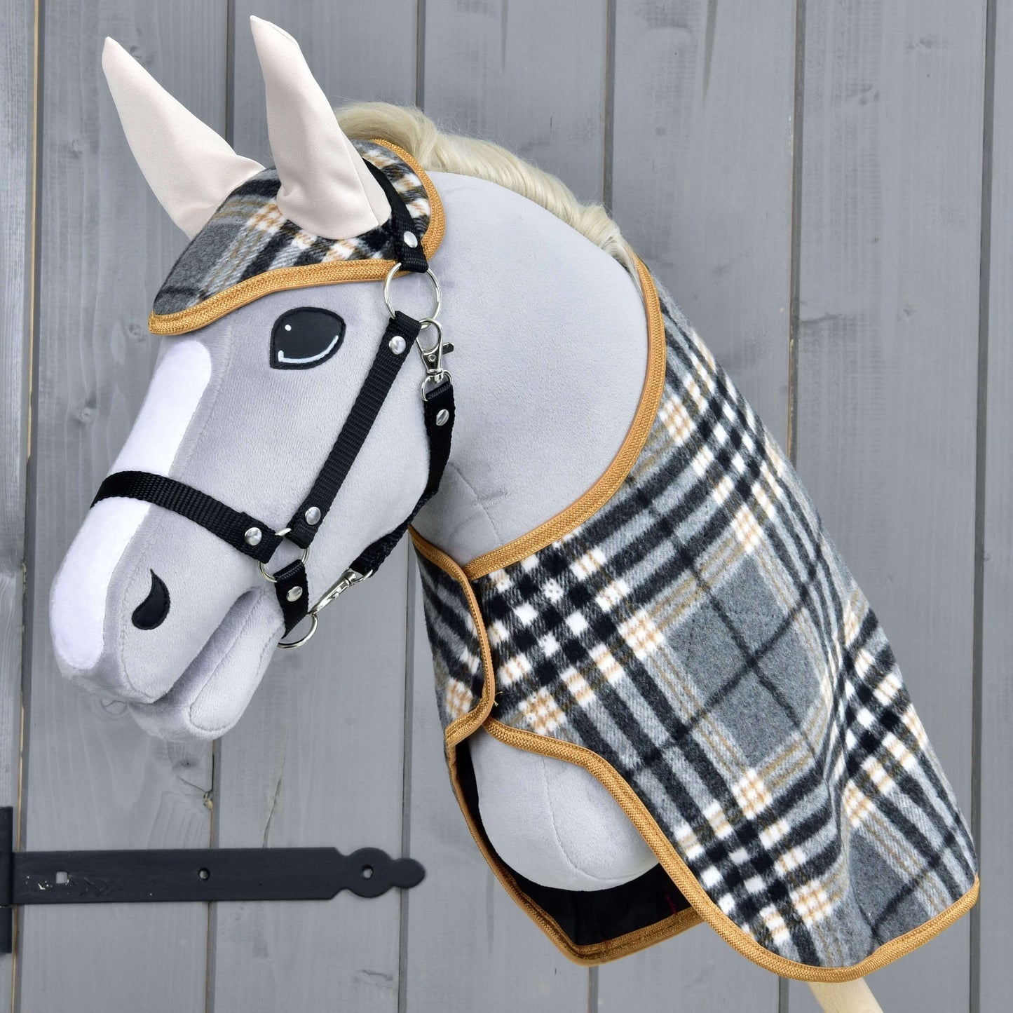 Hobby Horse LarDen Set England Grey se šedým plyšovým Hobby Horse, černou uzdečkou a otěžemi, kostkovanou dekou a ladící čabrakou, vytvářející půvabnou dekoraci na dřevěném pozadí.