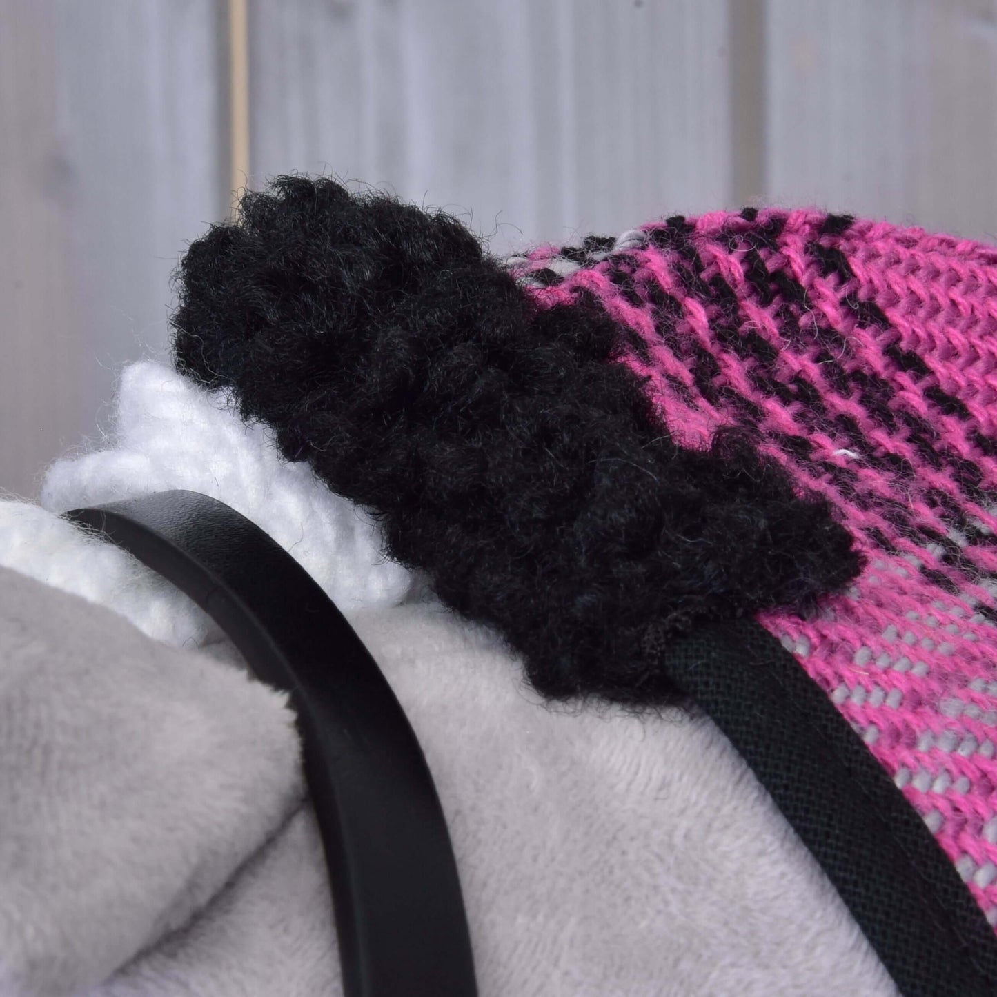 Detail Set Harmony Pink od Hobby Horse LarDen: růžová a černá pletená látka s chlupatým černým okrajem, bílým texturovaným detailem a hladkým černým řemínkem ohlávky na světle šedém pozadí.