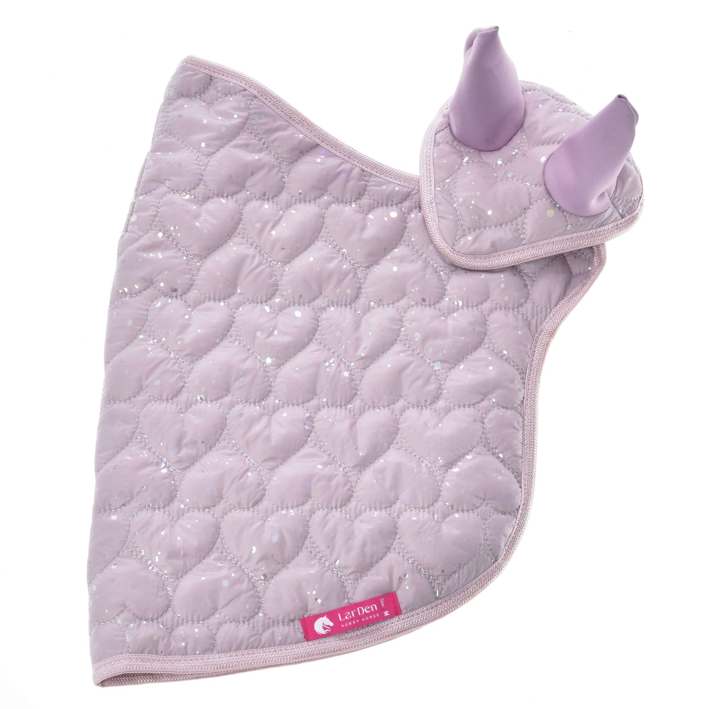 Set Sweetest Heart od Hobby Horse LarDen je světle fialová čabraka s prošíváním do srdcí, třpytivými detaily, dvěma vztyčenými kryty uší a růžovým štítkem Laz Dress — ideální ke kombinaci s vaší oblíbenou dekou pro Hobby Horse.