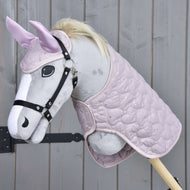 Hobby Horse LarDen Set Sweetest Heart obsahuje plyšový Hobby Horse se světle šedým obličejem, černou uzdečkou, světlou hřívou, růžovými ušima s čabrakou a prošívanou růžovou dekou, zobrazený na dřevěném pozadí.