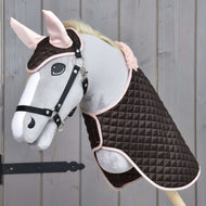 Hobby Horse LarDen Set Thermo Sweety s plyšovým Hobby Horse s uzdečkou, oblečeným do prošívané hnědo-růžové deky a ladící čabraky, vystavený na dřevěném pozadí.