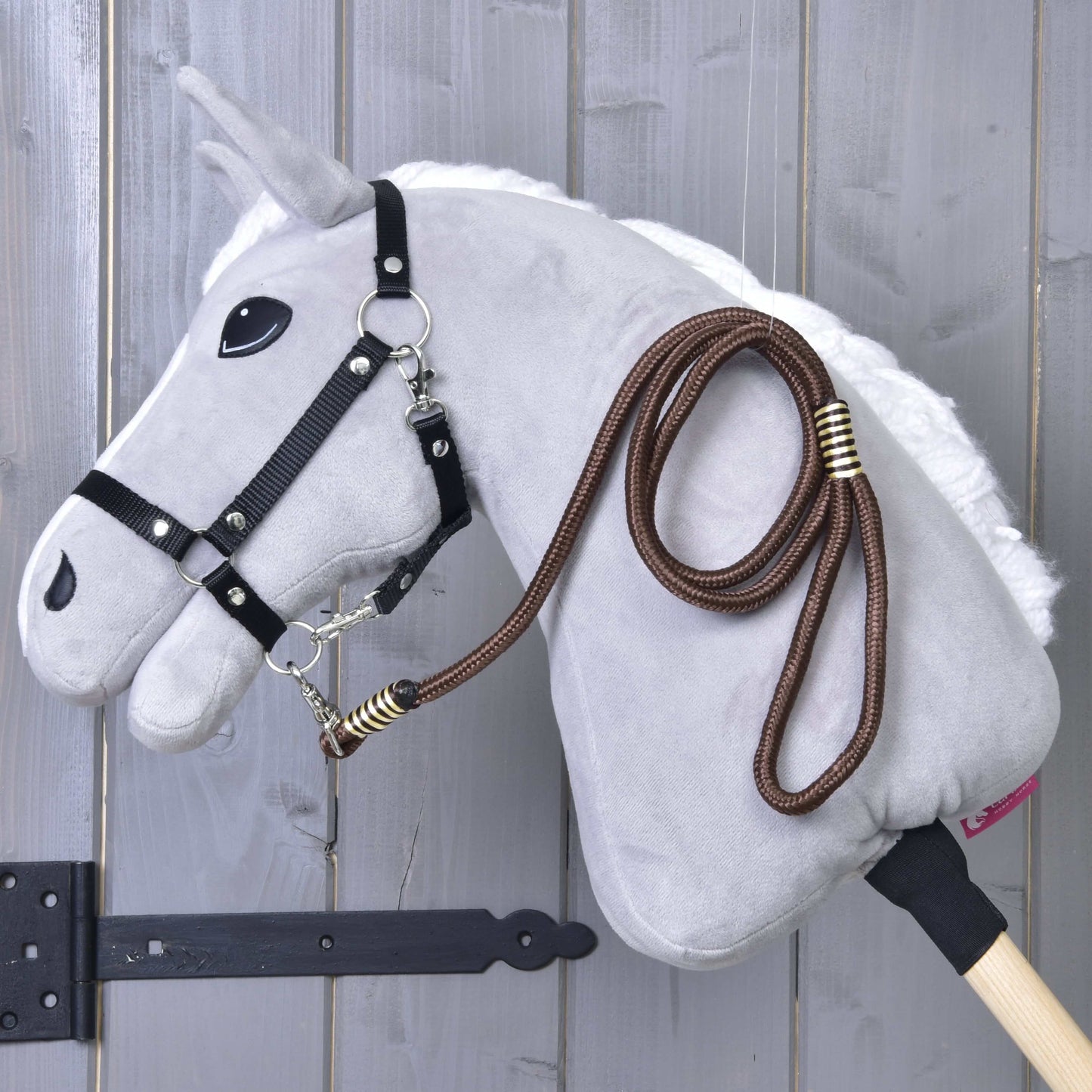 Hobby Horse - vodítko Vivaldi od Hobby Horse LarDen zavěšené na dřevěném nástěnném držáku na pozadí šedého dřeva.