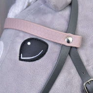 Detail „Kompletní uzdečky šedé s růžovou čelenkou“ od Hobby Horse LarDen na plyšovém koni, zobrazující černě prošité oko a detailní popruhy upevněné kovovým nýtem.