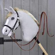Westernové otěže Dark Brown od Hobby Horse LarDen na šedém plyšovém hobby horse s černou uzdečkou, nasazeném na dřevěné tyči před šedou dřevěnou stěnou.