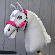 Ručně vyrobený šedý Hobby Horse od Hobby Horse LarDen s bílou hřívou a lysinou, s černou ohlávkou z koženky s kompletním růžovým beránkem, na dřevěném pozadí.