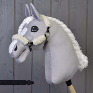 Plyšový šedý Hobby Horse od Hobby Horse LarDen s černou ohlávkou s kompletním beránkem a detaily z koženky, na dřevěné tyči před pozadím z dřevěných prken.