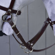 Detail Martingale hnědý od Hobby Horse LarDen s hnědou koženou uzdečkou s kovovými přezkami a kroužky na světle šedé hlavě modelu koně na pozadí šedé dřevěné stěny.