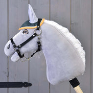 Čabraka Thermo Sport od Hobby Horse LarDen v zelené a žluté barvě na šedém plyšovém Hobby Horse s bílou hřívou a černou uzdečkou, nasazeném na dřevěné tyči před šedou dřevěnou stěnou.